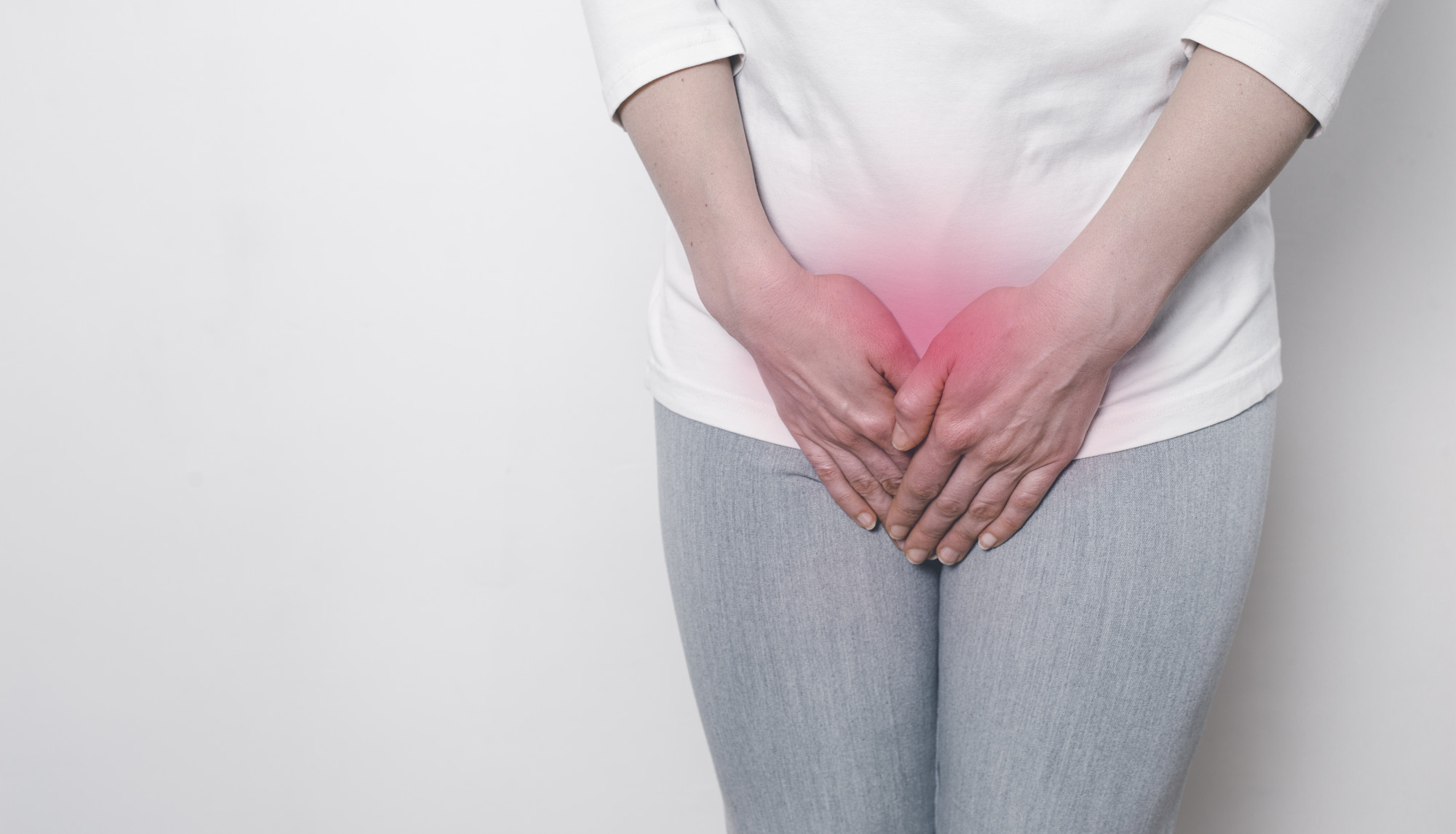 A woman holds her hands for a sore crotch. Gynecological problems in the lower abdomen. Inflammation of the bladder.