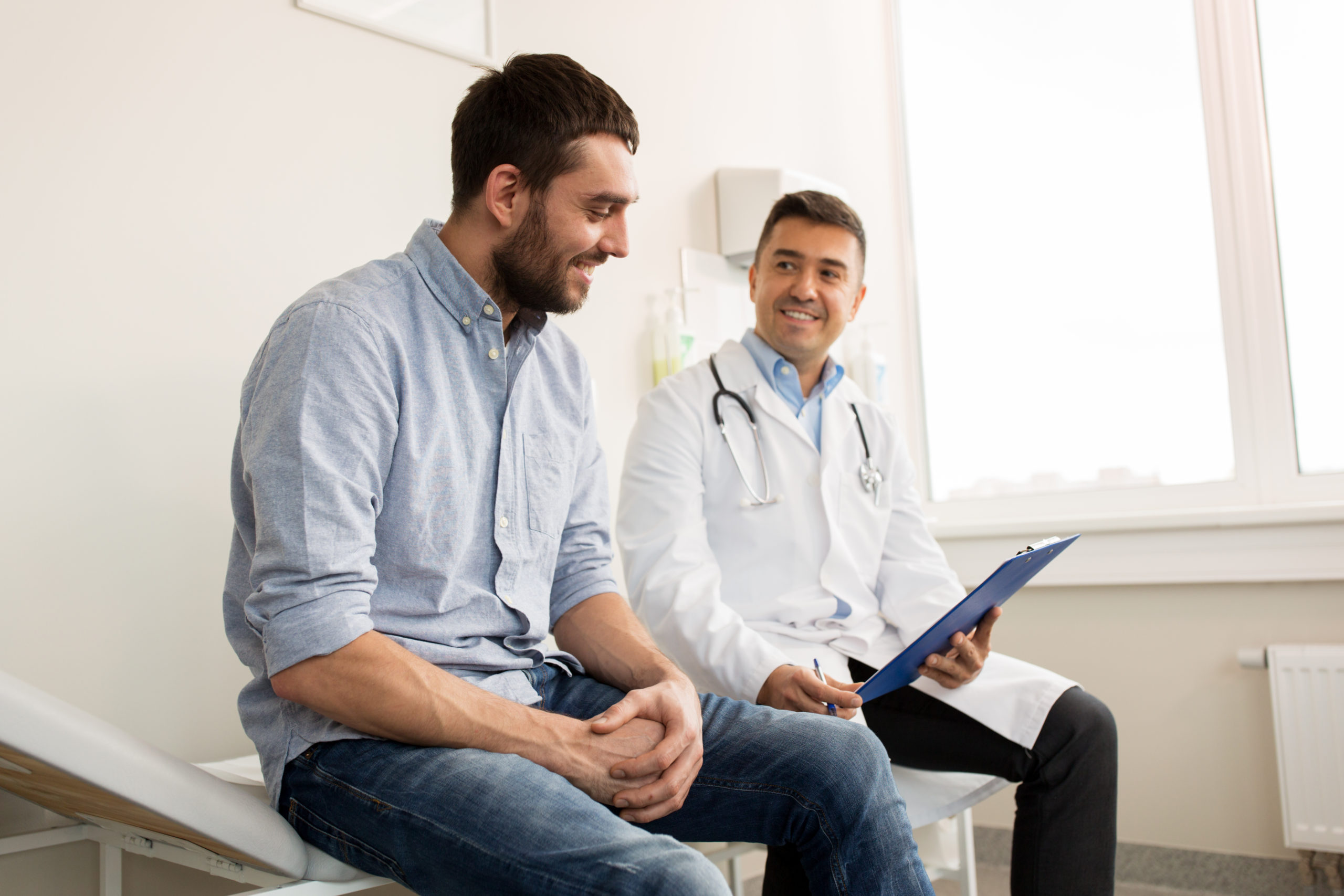 Patient sitting with a doctor looking at a clipboard